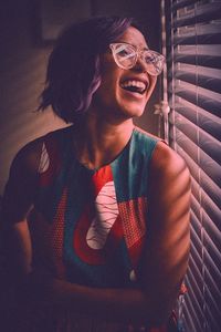 Laughing woman looking through window