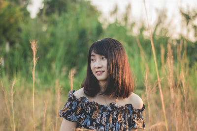 Smiling young woman standing on field