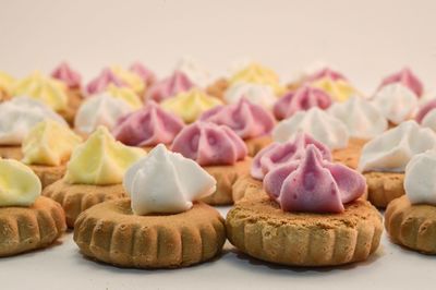 Close-up of colorful icing on cookies against white background