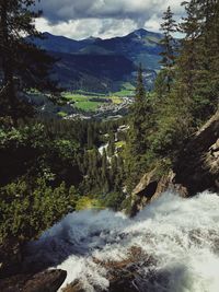 Scenic view of waterfall in forest against sky