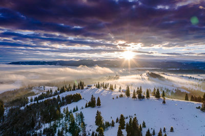 Scenic view of snow covered landscape against sky during sunset