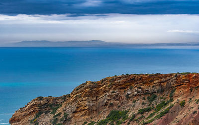 Scenic view of sea and mountains against sky