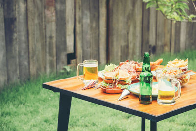 Food and drink served on table in backyard