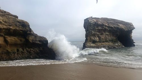 Scenic view of rocks in sea against sky