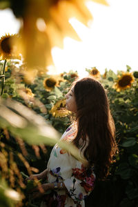 Side view of young woman looking at plants