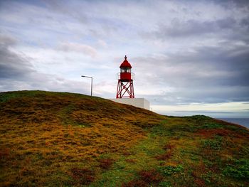 Lighthouse on land against sky