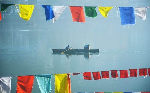 Multi colored flags hanging on boat in sea