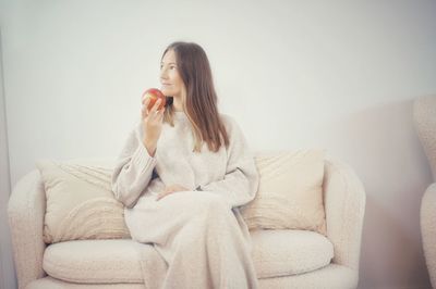 Young woman sitting on sofa at home