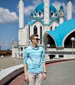 Full length of mature man standing against building in city