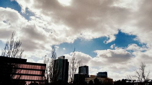 Low angle view of modern building against cloudy sky