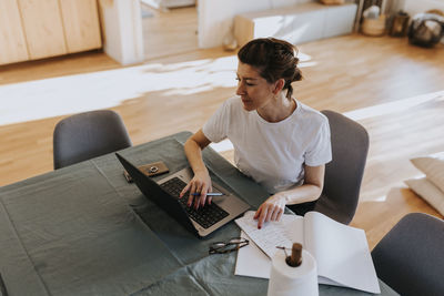 Smiling woman using laptop at home