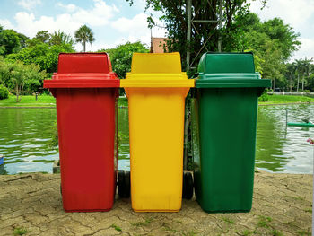 Multi colored chairs on table by lake