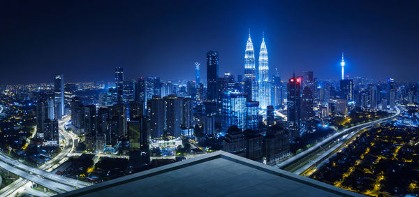 Panoramic view of illuminated cityscape against clear sky at night