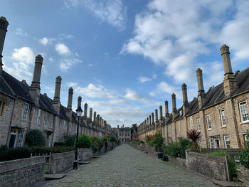 Footpath amidst buildings against sky