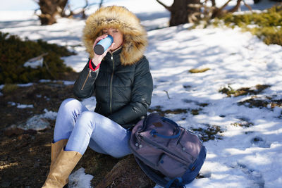 Low section of woman sitting on snow