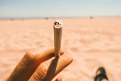Close-up of hand holding marijuana joint outdoors