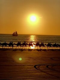 Silhouette people on beach during sunset