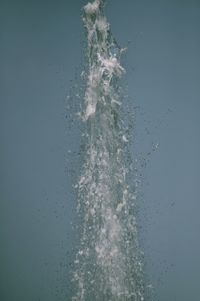 Close-up of splashing water against blue background