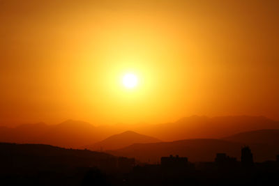 Scenic view of silhouette mountains against romantic sky at sunset
