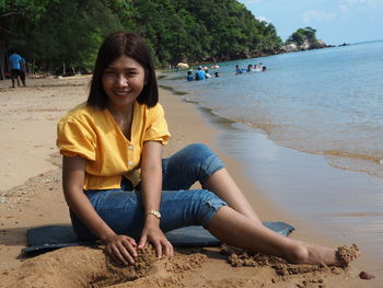 Friends sitting on shore at beach