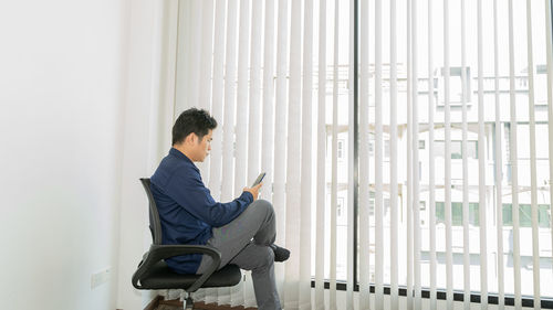 Side view of businessman using mobile phone in office