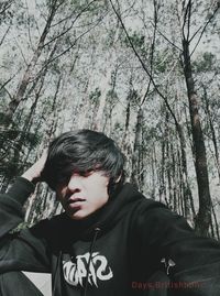 Portrait of boy against trees in forest