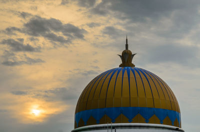 Low angle view of dome against cloudy sky during sunset