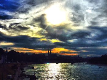 Scenic view of sea against cloudy sky at sunset