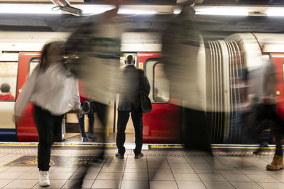 Businessman surrounded by commuters at subway station