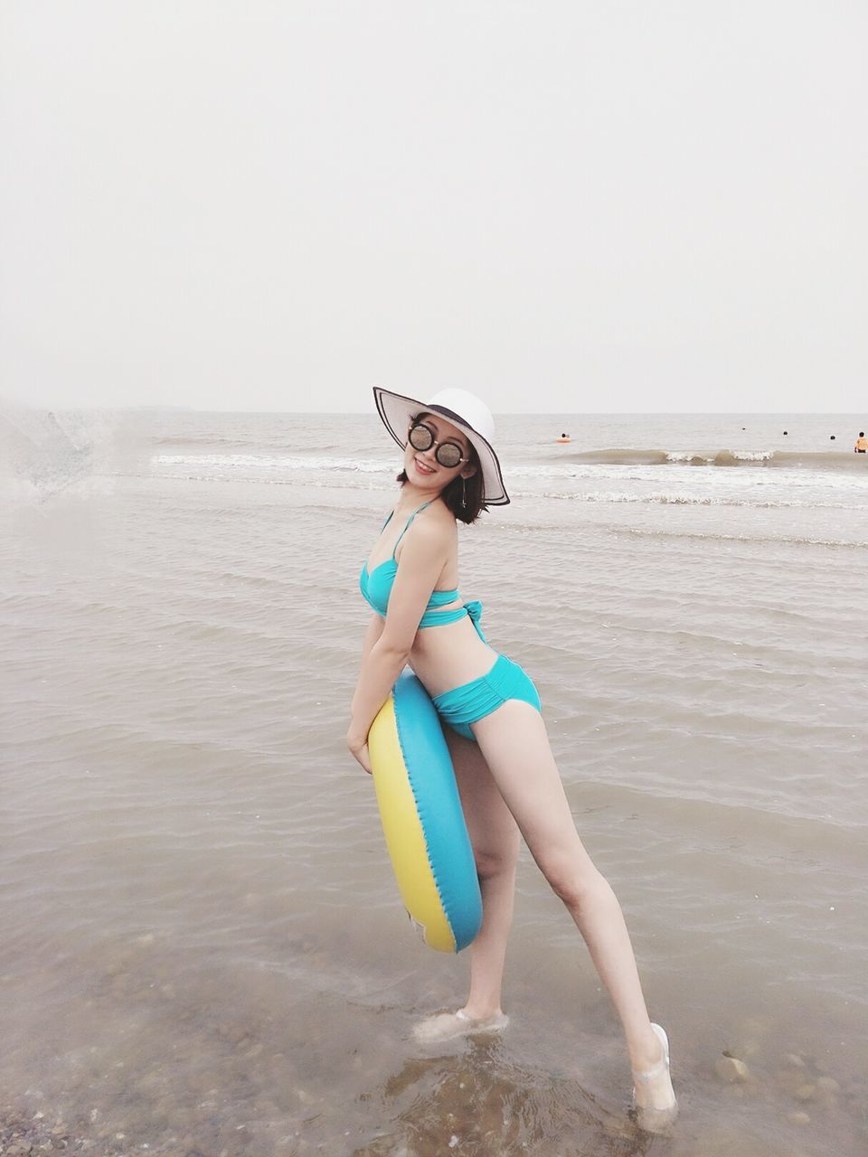 FULL LENGTH OF YOUNG WOMAN STANDING ON BEACH