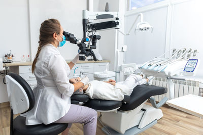 Side view of female doctor examining patient at clinic