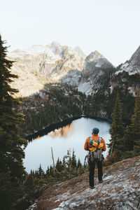 Rear view of hiker standing on hill while looking at thorton lakes