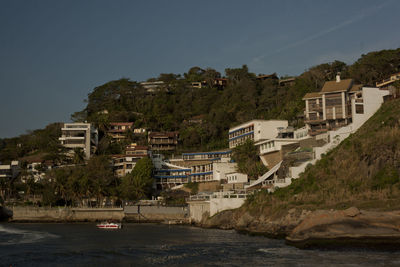 Buildings by sea against sky in city