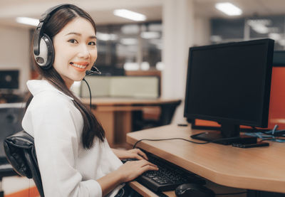 Portrait of a smiling young woman using mobile phone