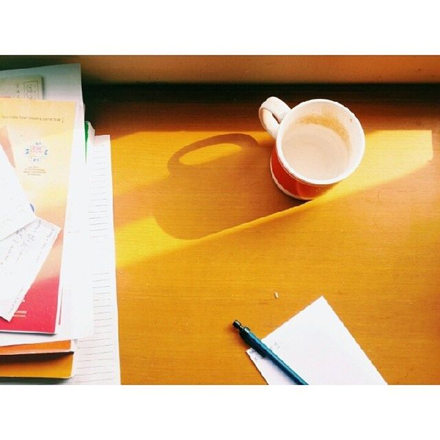 table, indoors, coffee cup, drink, food and drink, refreshment, still life, transfer print, coffee - drink, auto post production filter, book, high angle view, paper, cup, close-up, coffee, saucer, freshness, no people, wood - material