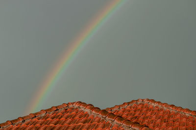 Low angle view of rainbow over house against sky