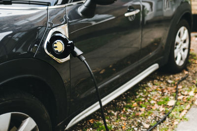 Close-up of electric car on street being charged