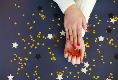 Cropped hands of woman with star shape on colored background