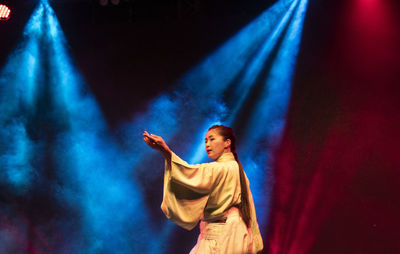 Young woman with arms raised