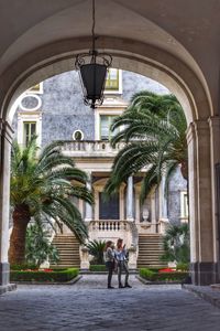 People standing by palm trees and building