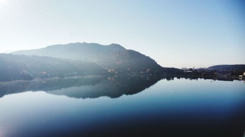 Reflection of mountains in lake against clear sky