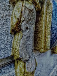 Close-up of old statue against wall