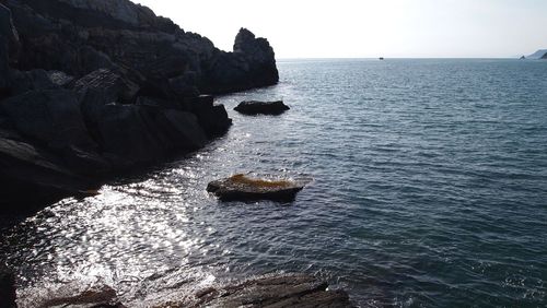 Rock formation in sea against sky