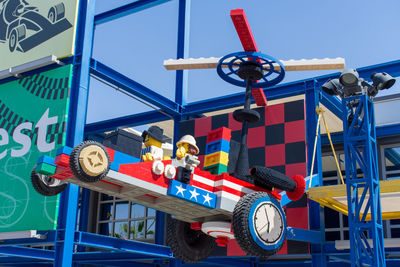 Low angle view of shopping cart against blue sky