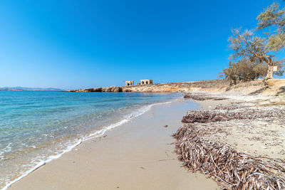 Scenic view of beach against clear blue sky