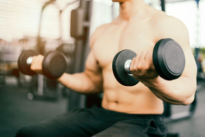 Midsection of man exercising in gym