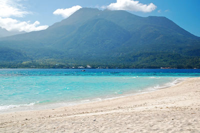 Scenic view of sea and mountains against sky