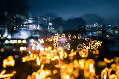 A beautiful, abstract scene of fire spinners in london at the bank of thames. 