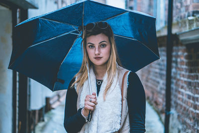 Portrait of beautiful woman holding umbrella