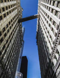 Low angle view of skyscrapers against blue sky